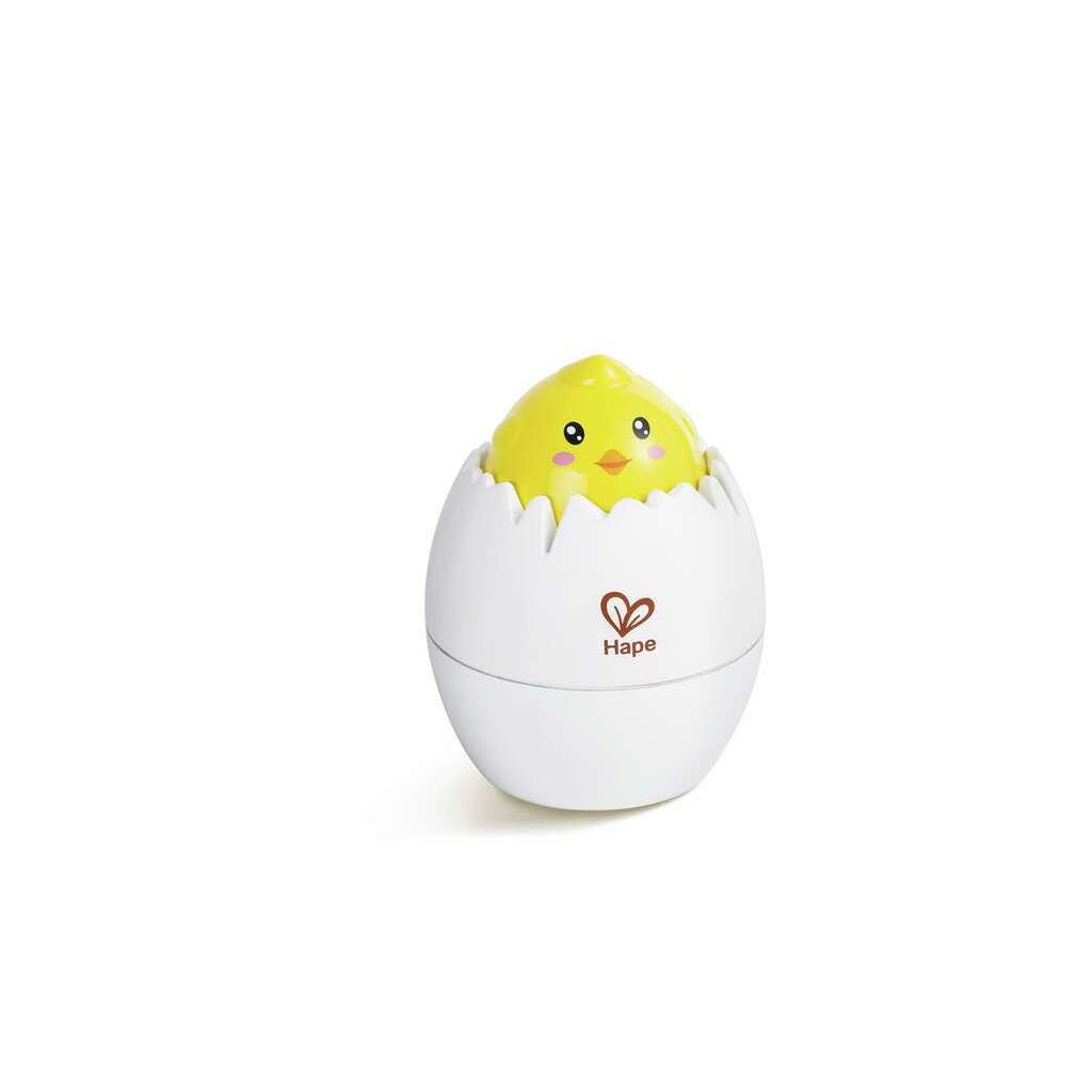 A yellow chick toy partially emerges from a white transformation egg-shaped container adorned with the "Hape" logo, cleverly designed to foster cognitive growth.