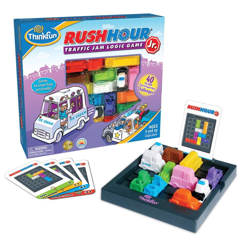 The ThinkFun Rush Hour Junior game set features colorful vehicles on a grid and a box displaying the game. This STEM toy includes challenge cards designed for ages 5 and up, offering young minds an engaging Traffic Jam Logic Game experience.