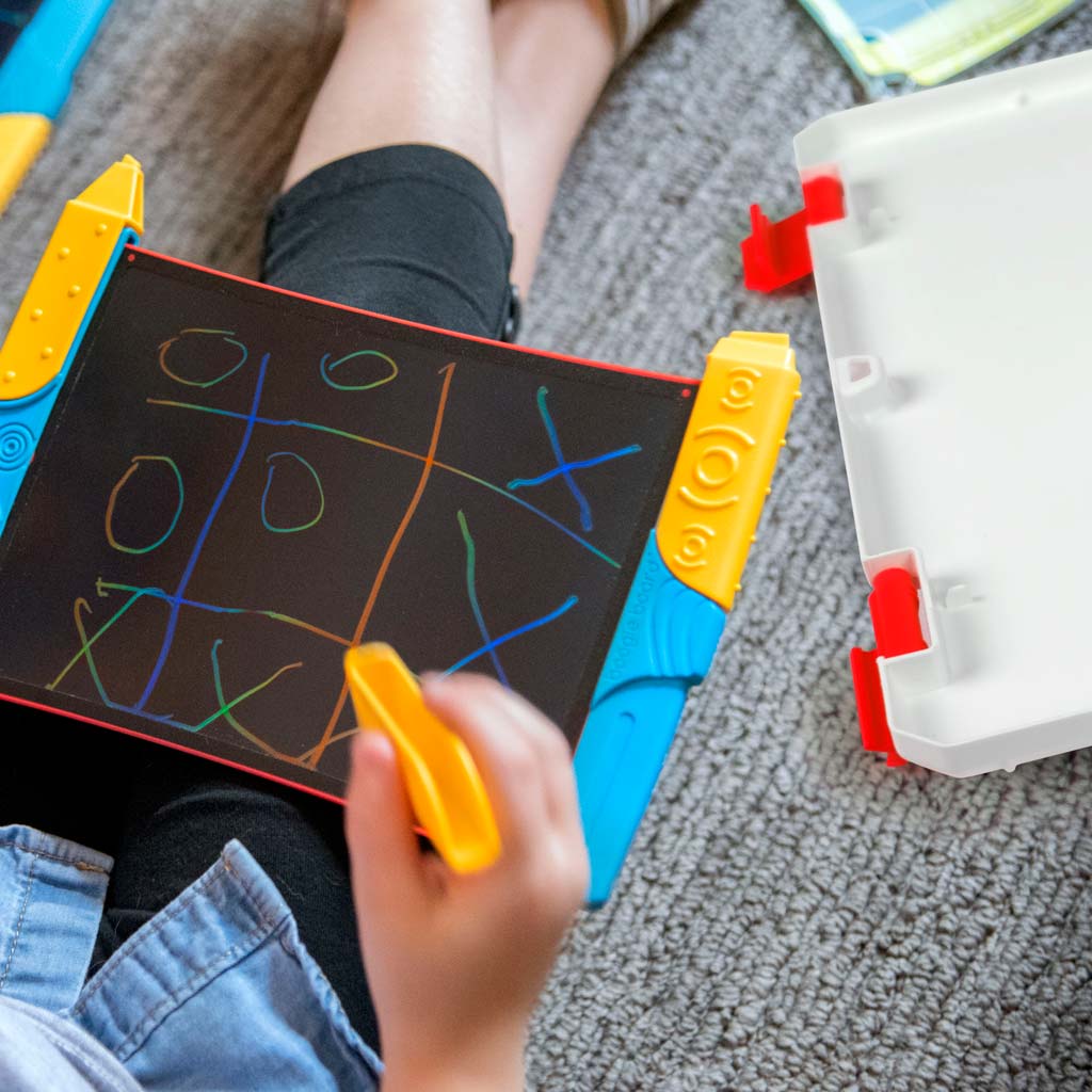 another child is playing tic tac toe with the boogie board, the clear plastic case is in the background