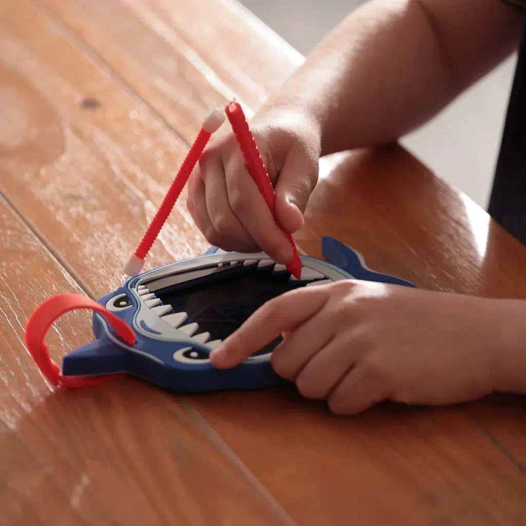 a child is doodling on a boogie board. 