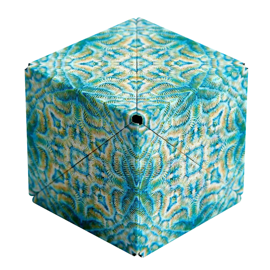 A Shashibo cube with intricate, symmetrical fern-like patterns in blue and green hues intriguingly transforms as if hidden by rare earth magnets.