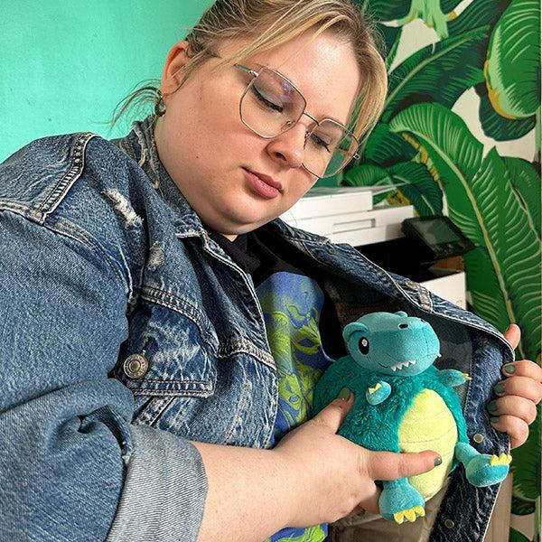 Person holding dinosaur plush