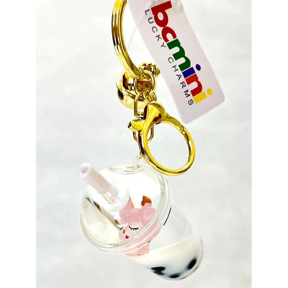 Keychain featuring a miniature bubble tea with a unicorn design inside a clear cup. This whimsical key charm comes with a gold clasp, branded tag, and assorted designs that include silly animals for added fun.