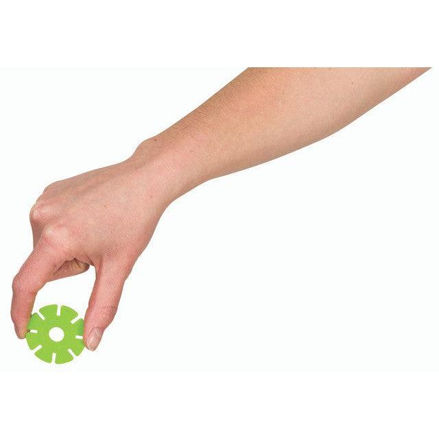 A hand holds a small green circular object with cut-out sections, resembling a Toysmith's clever take on a succulent sculpture.