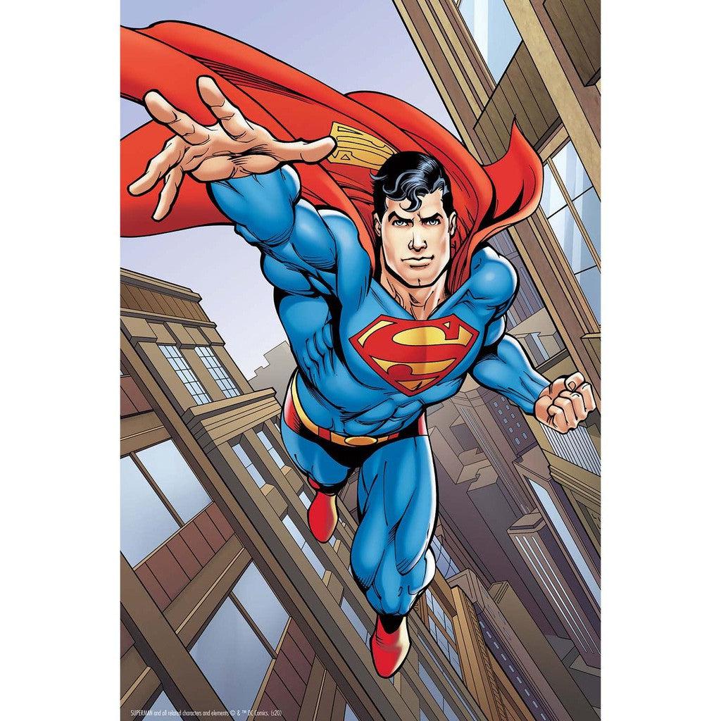 A superhero in a blue suit and red cape, it's Superman from DC Comics, flies through a cityscape, extending one arm forward.