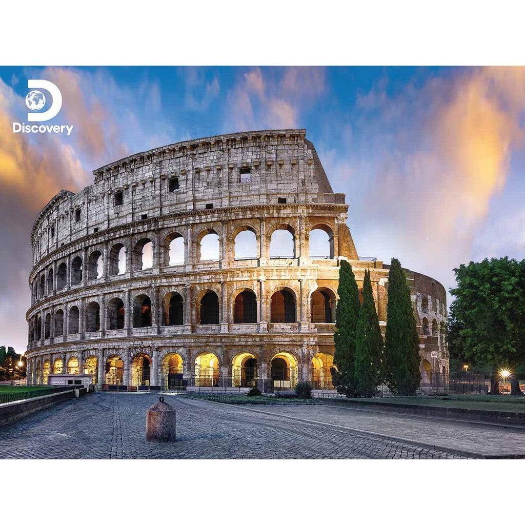 The Colosseum in Rome basks under a vibrant sky, its arches aglow with warm lights. A perfect snapshot, it feels like piecing together a captivating puzzle. The Discovery logo graces the top left corner.