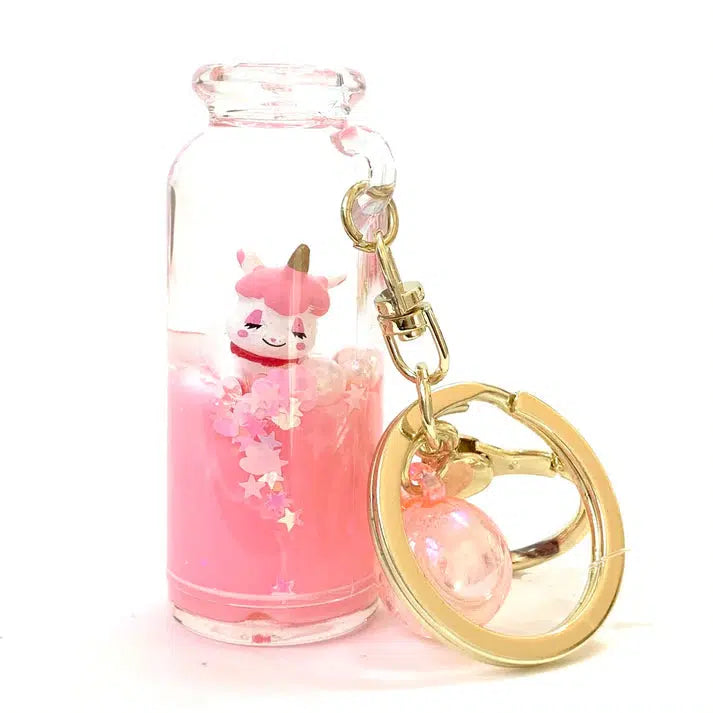 Introducing the UNICORN LOVE FLOATY KEY CHARM—this whimsical keyring showcases a small glass bottle filled with pink liquid, a cute unicorn figure, and star-shaped confetti. Perfect for anyone who adores magical creatures.