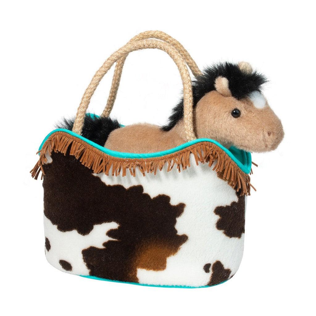 The Western Sassy Pet Sak holds a plush horse toy with a fluffy mane, nestled inside its cow-print bag adorned with imitation buckskin fringe and rope handles—a perfect addition to your collection of cowgirl accessories.