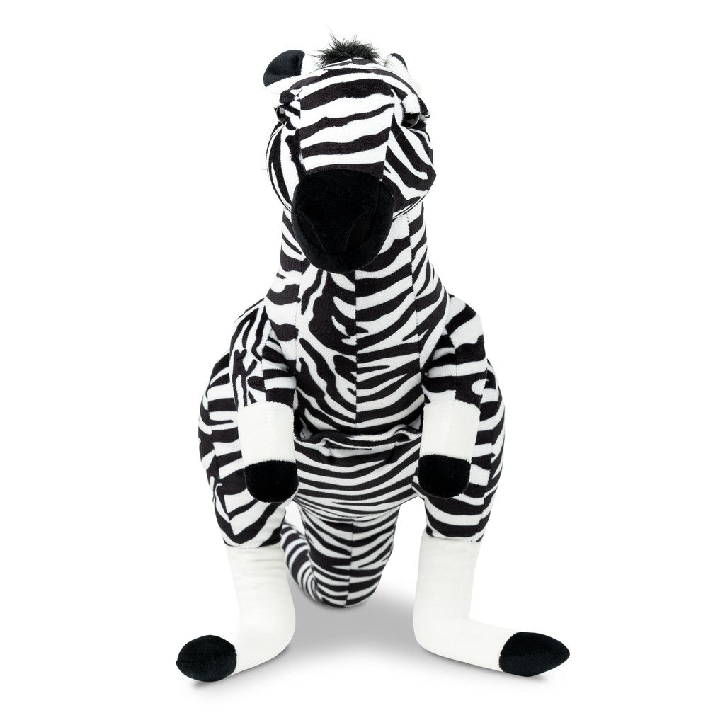 A plush zebra toy with black and white stripes sits against a plain black background.